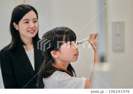 ホワイトボードに回答を書く小学生の女の子 ホワイトボードに回答を書く小学生の女の子 106291976
