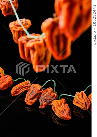 Sun-dried persimmon layered on a dark background close-up, selective focus. Vertical frame. Traditional healthy Japanese dried persimmon dessert Sun-dried persimmon layered on a dark background close-up, selective focus. Vertical frame. Traditional healthy Japanese dried persimmon dessert 106292441