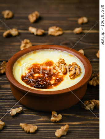 Baked rice pudding - turkish milk dessert sutlac in earthenware casserole with walnuts. Turkish Cuisine dessert varieties. Close up 106293580