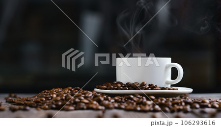 White cup with espresso coffee and grains on a wooden dark table 106293616