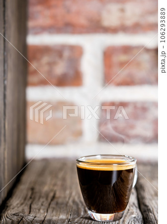 Cup with coffee espresso arranged on a old bricks background. Close up, selective focus, copy space, minimalism 106293889