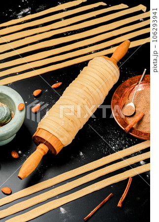 Cooking trdelnik. Baked delicacy on a skewer and charcoal dough with sugar, cinnamon and vanilla. Christmas sweets, street food. Czech and Moravian cuisine. Cooking trdelnik. Baked delicacy on a skewer and charcoal dough with sugar, cinnamon and vanilla. Christmas sweets, street food. Czech and Moravian cuisine. 106293941