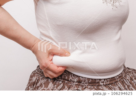 【お腹の肉を摘む主婦】 106294625