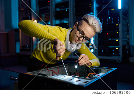Young IT woman repairing computer system unit using screwdriver 106295500