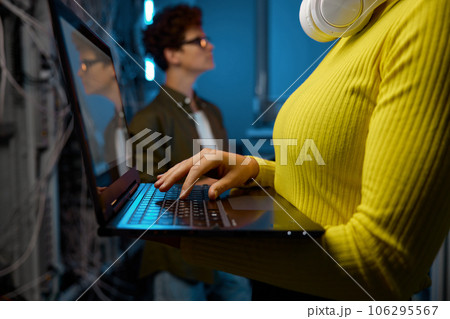 IT technicians working together with network hardware 106295567