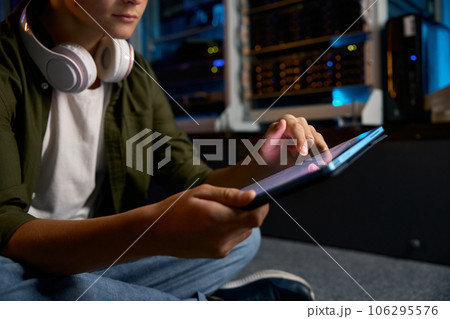 Teenager working at server, closeup view on hands using mobile tablet 106295576