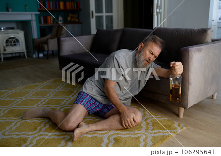 Senior man addicted to alcohol drinking hiding from his wife 106295641