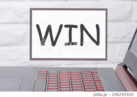 win an inscription on a magnetic board hanging on a brick wall 106295920