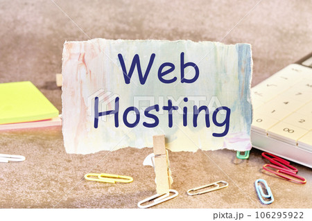 Web Hosting text written on paper next to scattered paper clips, calculator, adhesive paper 106295922