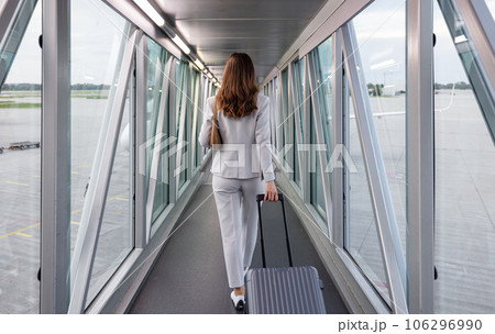 Businesswoman boarding the plane with carry-on 106296990