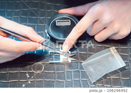 Close-up of jeweler sorting diamonds on her workbench Close-up of jeweler sorting diamonds on her workbench 106296992