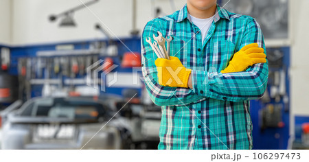 A repairman stands with open-end wrenches. 106297473