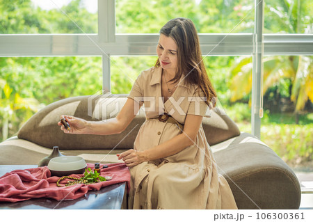 A serene moment captured as a pregnant woman after 40 embraces the soothing benefits of aroma oils and an aroma diffuser, enhancing her pregnancy journey with relaxation and tranquility A serene moment captured as a pregnant woman after 40 embraces the soothing benefits of aroma oils and an aroma diffuser, enhancing her pregnancy journey with relaxation and tranquility 106300361