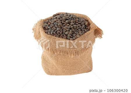 Dark lentils in the sack isolated on white. 106300420