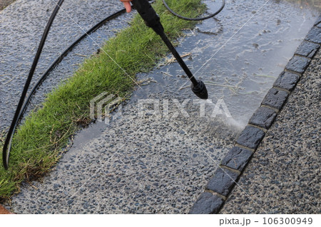 高圧洗浄機で玄関前アプローチの砂利入りコンクリートを綺麗にしている様子 大掃除 高圧洗浄機で玄関前アプローチの砂利入りコンクリートを綺麗にしている様子 大掃除 106300949