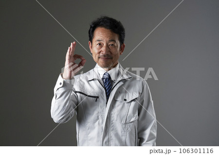 OKサインをするミドルエイジの作業員 黒背景 OKサインをするミドルエイジの作業員 黒背景 106301116