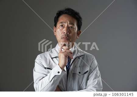 考えるミドルエイジの作業員　黒背景 106301145