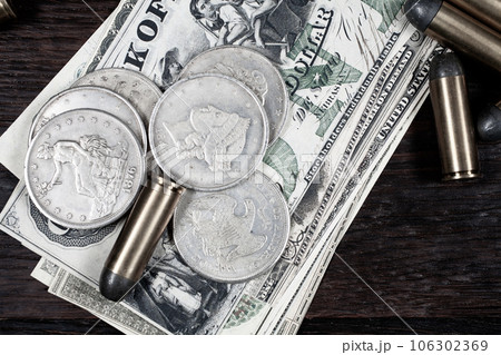 Old west period US banknotes and silver certificates with silver dollar coins and .45 caliber revolver ammunitions Old west period US banknotes and silver certificates with silver dollar coins and .45 caliber revolver ammunitions 106302369