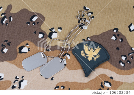 May 12, 2018. US ARMY Specialist rank patch and dog tags on desert camouflage uniform 106302384