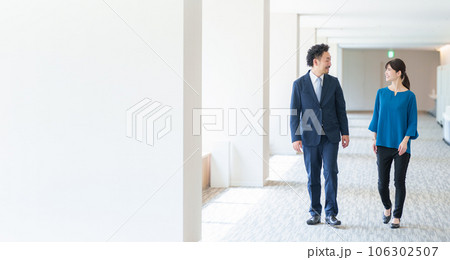 オフィスの通路を歩くビジネスパーソン 106302507