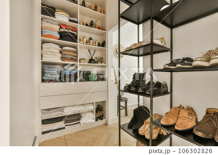 the inside of a walk - in closet with shoes and other items on shelves, as well as they do the inside of a walk - in closet with shoes and other items on shelves, as well as they do 106302826