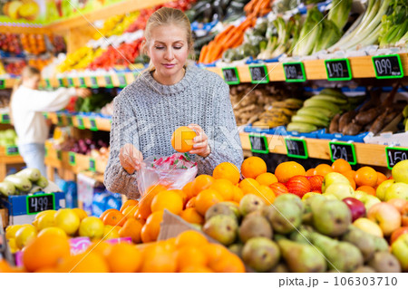 Smiling woman choosing sweet ripe oranges in farmer store Smiling woman choosing sweet ripe oranges in farmer store 106303710