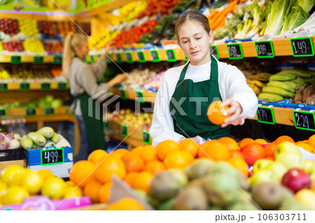 Focused young girl working at family fruit and vegetable shop Focused young girl working at family fruit and vegetable shop 106303711