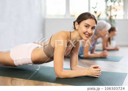 Women of different generations yoga showing plank pose in wellness center Women of different generations yoga showing plank pose in wellness center 106303724