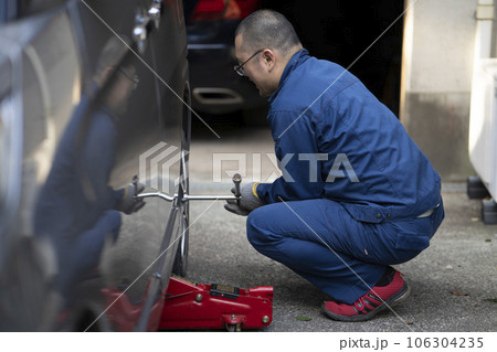 自動車のタイヤ交換をする整備士 106304235