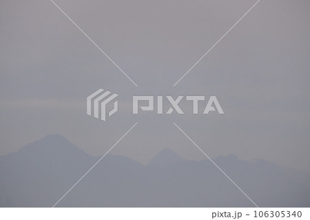 晩夏の朝の山並み　薄曇りの空に　浮かぶ山並みの青いシルエット　露出抑えめ 106305340