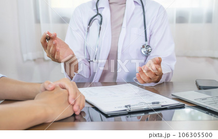 Doctor hand holding pen and explained examination results to the patient man, healthcare and medical checkup concept 106305500