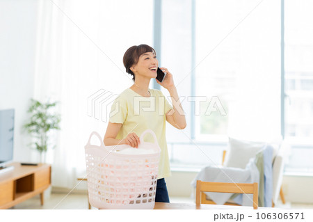 女性　洗濯　携帯電話　リビング 106306571