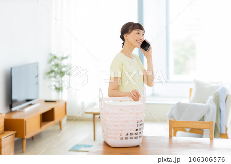 女性　洗濯　携帯電話　リビング 106306576