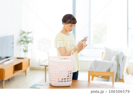 女性　洗濯　携帯電話　リビング 106306579