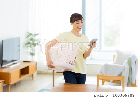 女性　洗濯　携帯電話　リビング 106306588