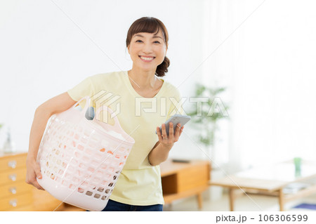 女性　洗濯　携帯電話　リビング 106306599