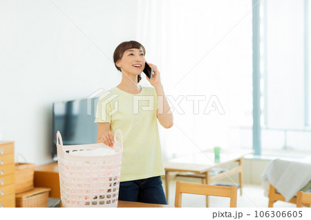 女性 洗濯 携帯電話 リビング 女性 洗濯 携帯電話 リビング 106306605