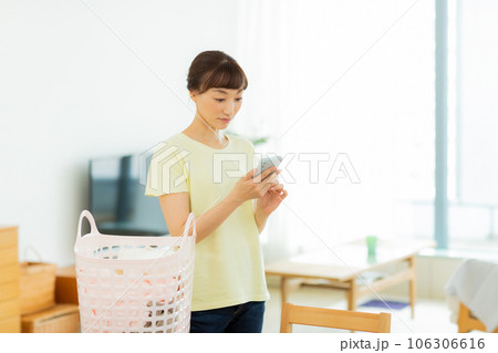 女性 洗濯 携帯電話 リビング 女性 洗濯 携帯電話 リビング 106306616