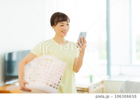 女性　洗濯　携帯電話　リビング 106306638
