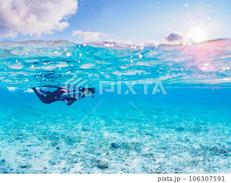 美しい白砂のビーチで泳ぐダイバーの半水面撮影（沖縄県島尻郡慶良間諸島座間味島阿真ビーチ） 106307591