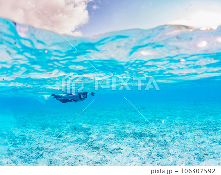 美しい白砂のビーチで泳ぐダイバーの半水面撮影（沖縄県島尻郡慶良間諸島座間味島阿真ビーチ） 106307592