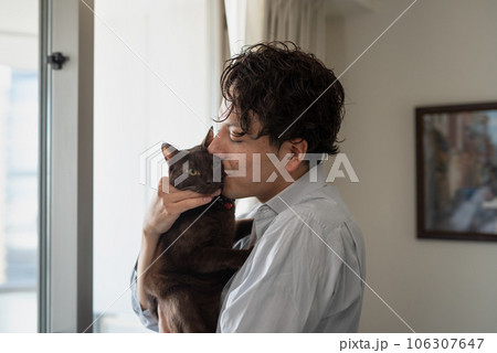 ペットの猫にキスする飼い主の男性 106307647