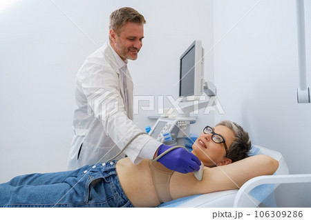 Mature woman has a ultrasound lymph nodes in area under the armpits in medical clinic 106309286
