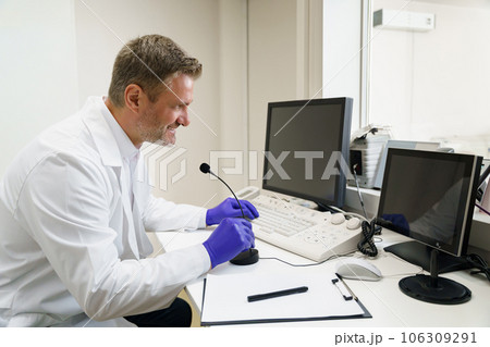 Doctor radiologist controls MRI or CT or PET Scan with patient undergoing procedure 106309291