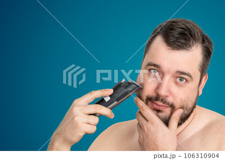 unshaven young man perfect skin hold electric razor shaving, isolated. Grooming for the modern man 106310904