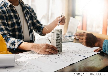 Engineer teams meeting working together wear worker helmets hardhat on construction site in modern city.Asian industry professional team 106311165
