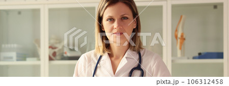 Portrait of a doctor woman at a table in a clinic, close-up Portrait of a doctor woman at a table in a clinic, close-up 106312458