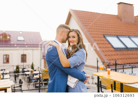 Beautiful young couple in love is walking in the fresh air on a city street, hugging 106312693