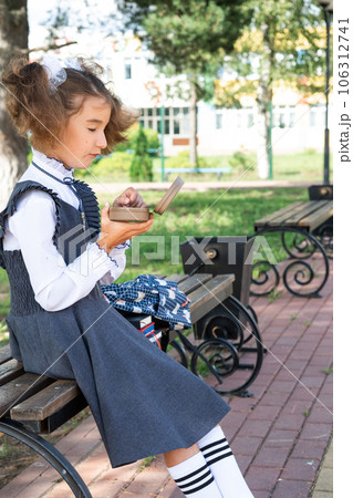Girl with backpack eating sandwich packed in a sandwich box near school. A quick snack with a bun, unhealthy food, lunch from school. Back to school. Education, primary school classes, September 1 Girl with backpack eating sandwich packed in a sandwich box near school. A quick snack with a bun, unhealthy food, lunch from school. Back to school. Education, primary school classes, September 1 106312741