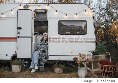 Caucasian woman sits in a van on a warm autumn day. Travel in a camper. Caucasian woman sits in a van on a warm autumn day. Travel in a camper. 106313489